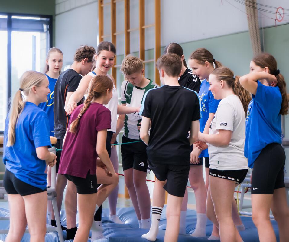 Kooperative Teamspiele Jugendliche als Gruppe in der Halle